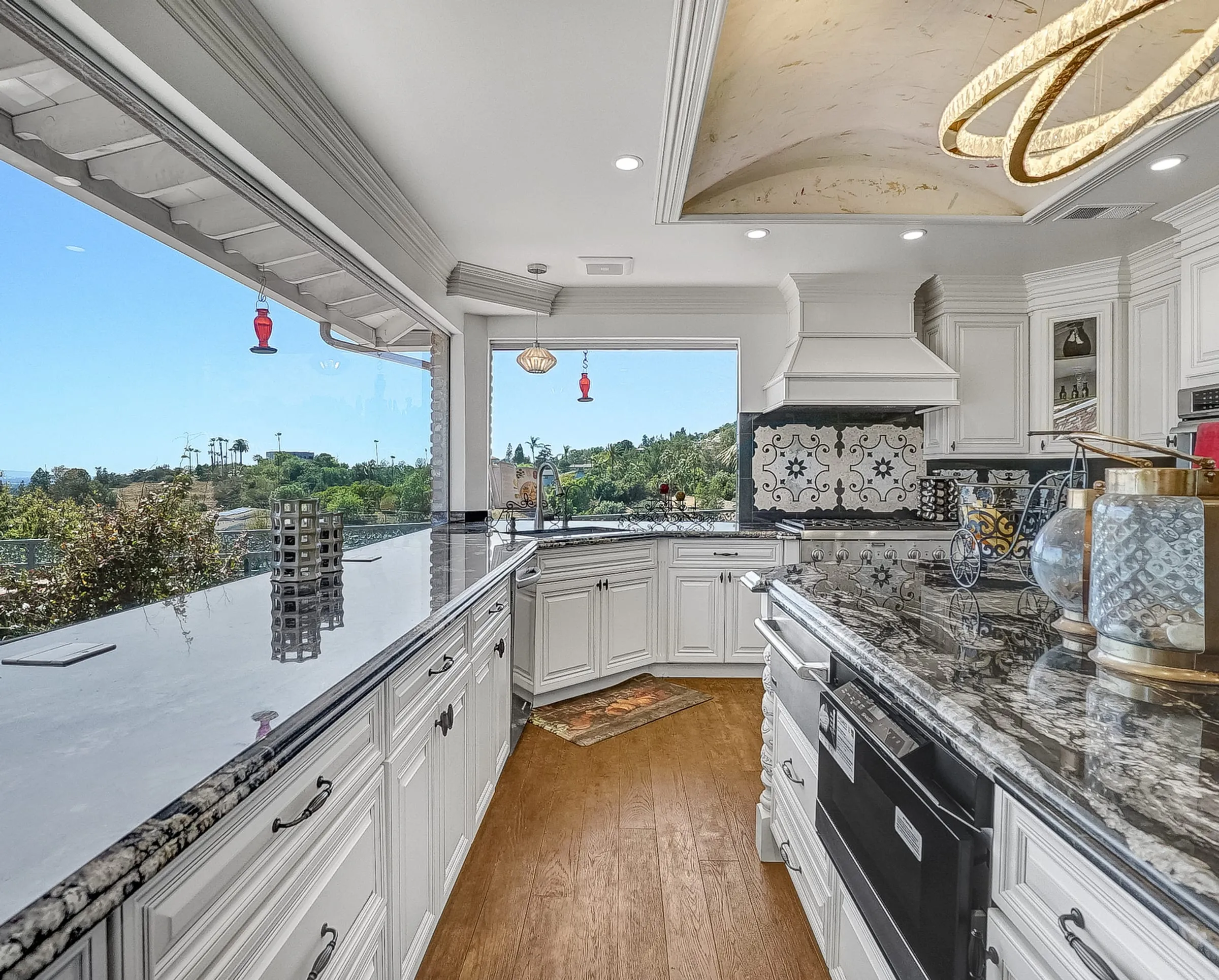 White glazed kitchen with black granite tops and hilltop view windows