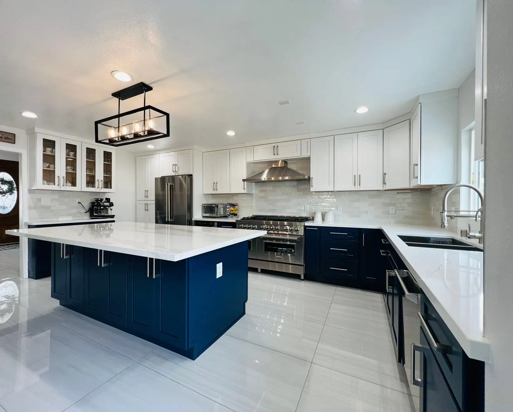 Navy island and white perimeter kitchen with a white quartz island top
