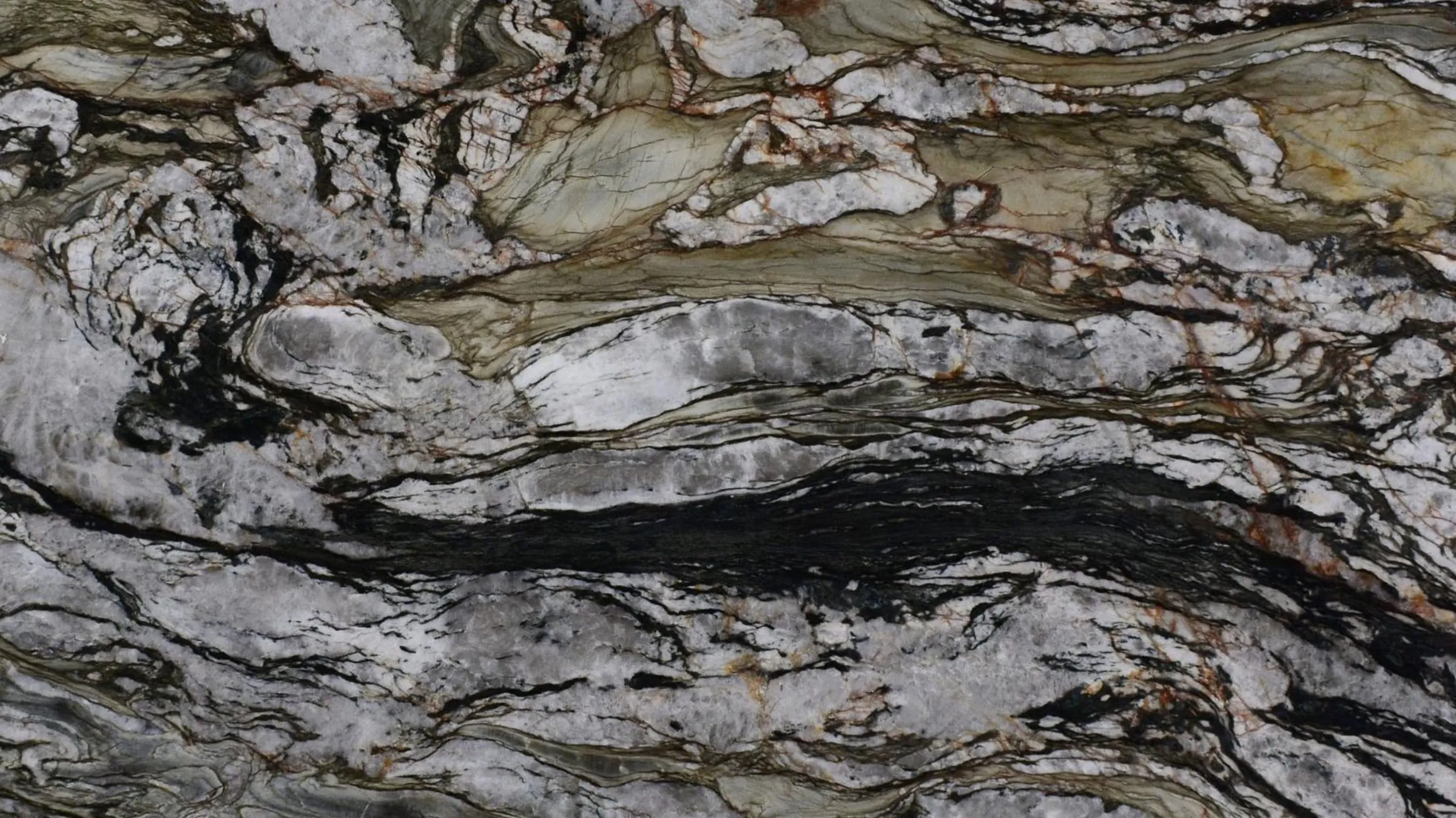 Tempest Crystal quartzite slab with a leathered surface, silver white with black seams and rust threading