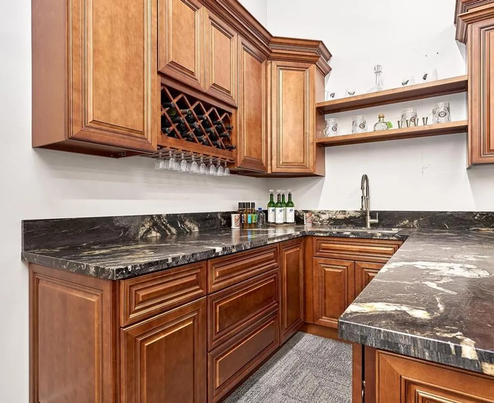 Cherry-glaze wet bar with black granite and a wine-lattice upper cabinet