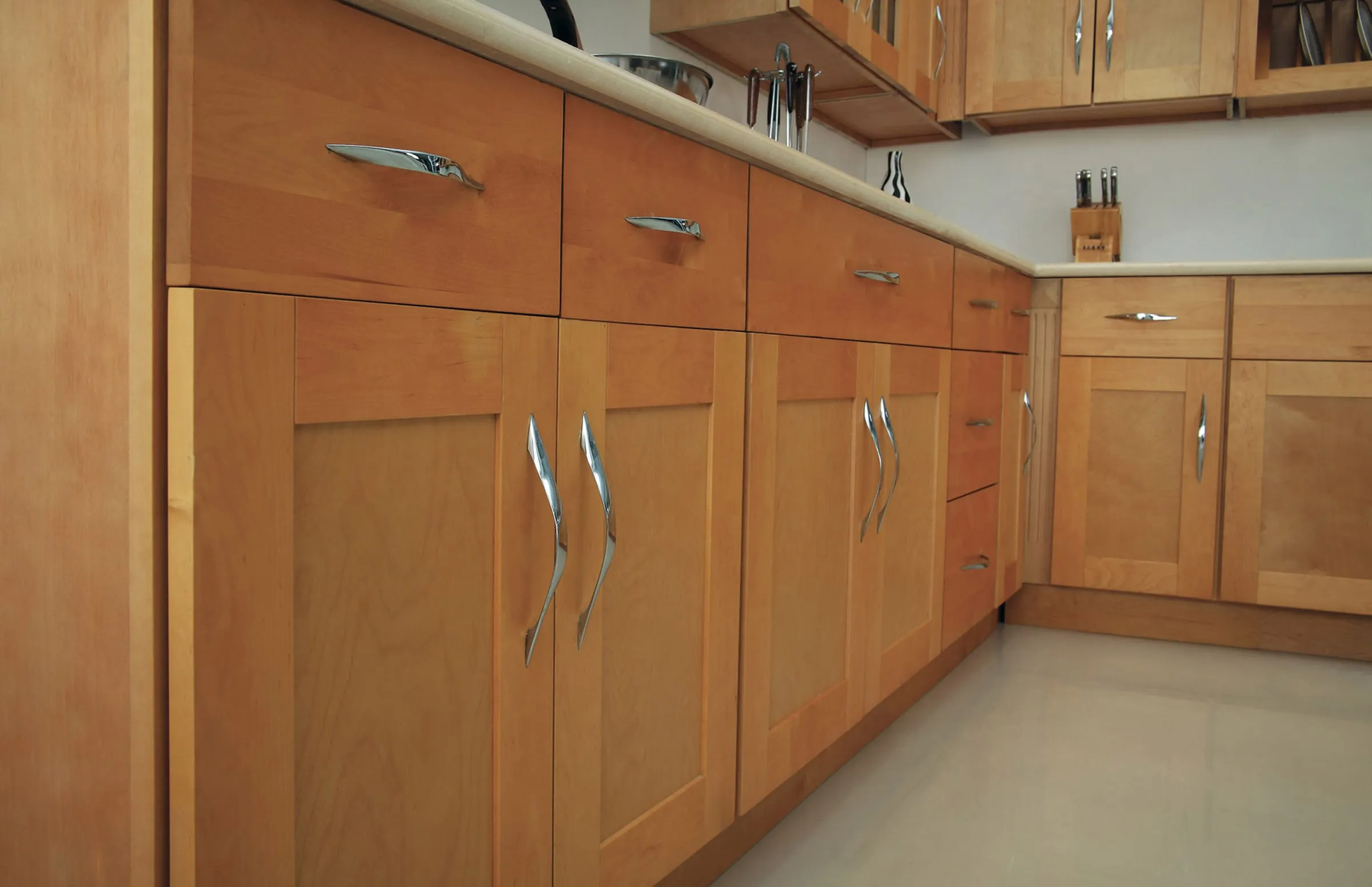 Close view of a Honey shaker base cabinet run with satin-nickel bar pulls