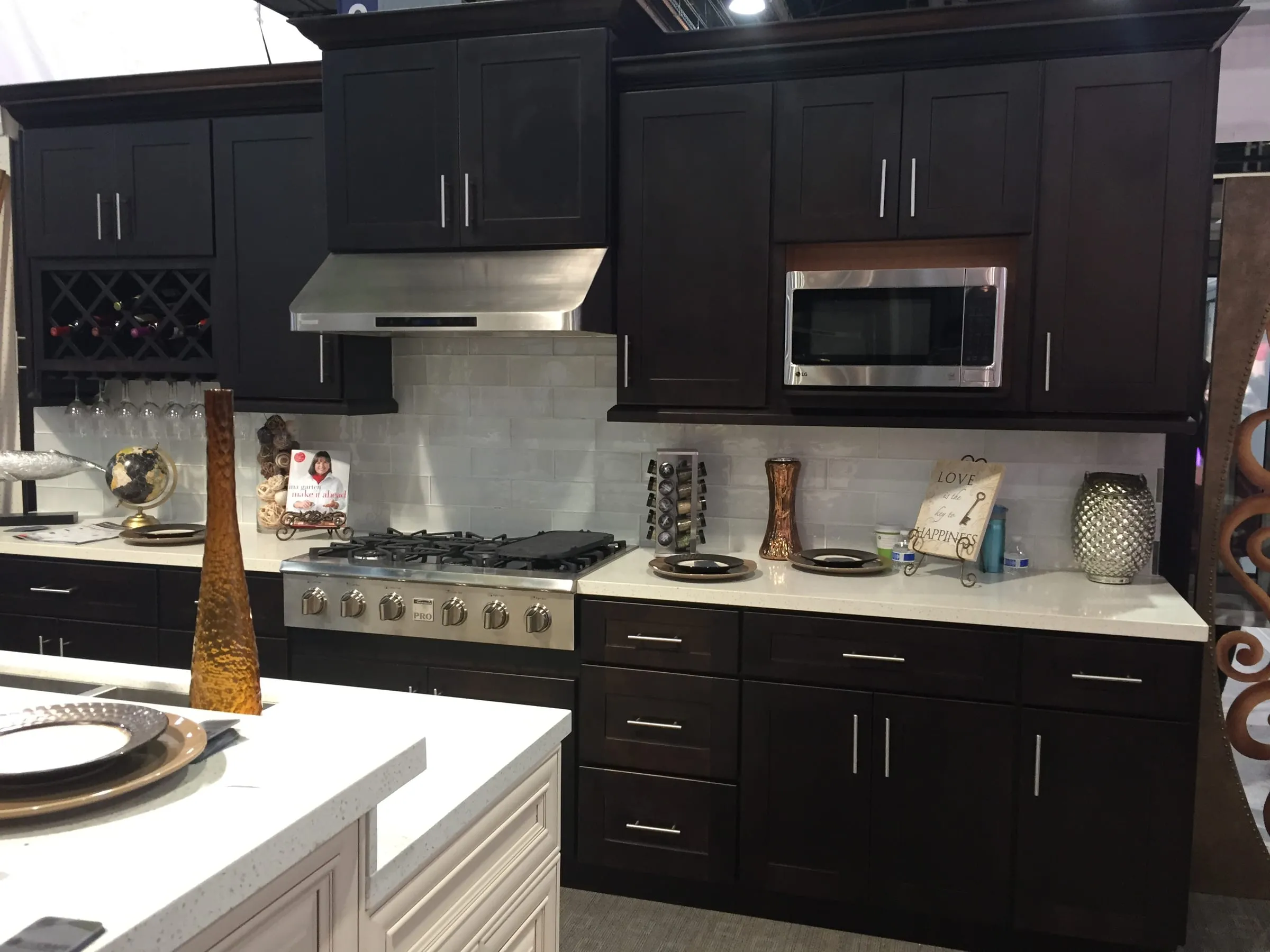 Java shaker cabinets around a gas cooktop and over-range microwave with light counters