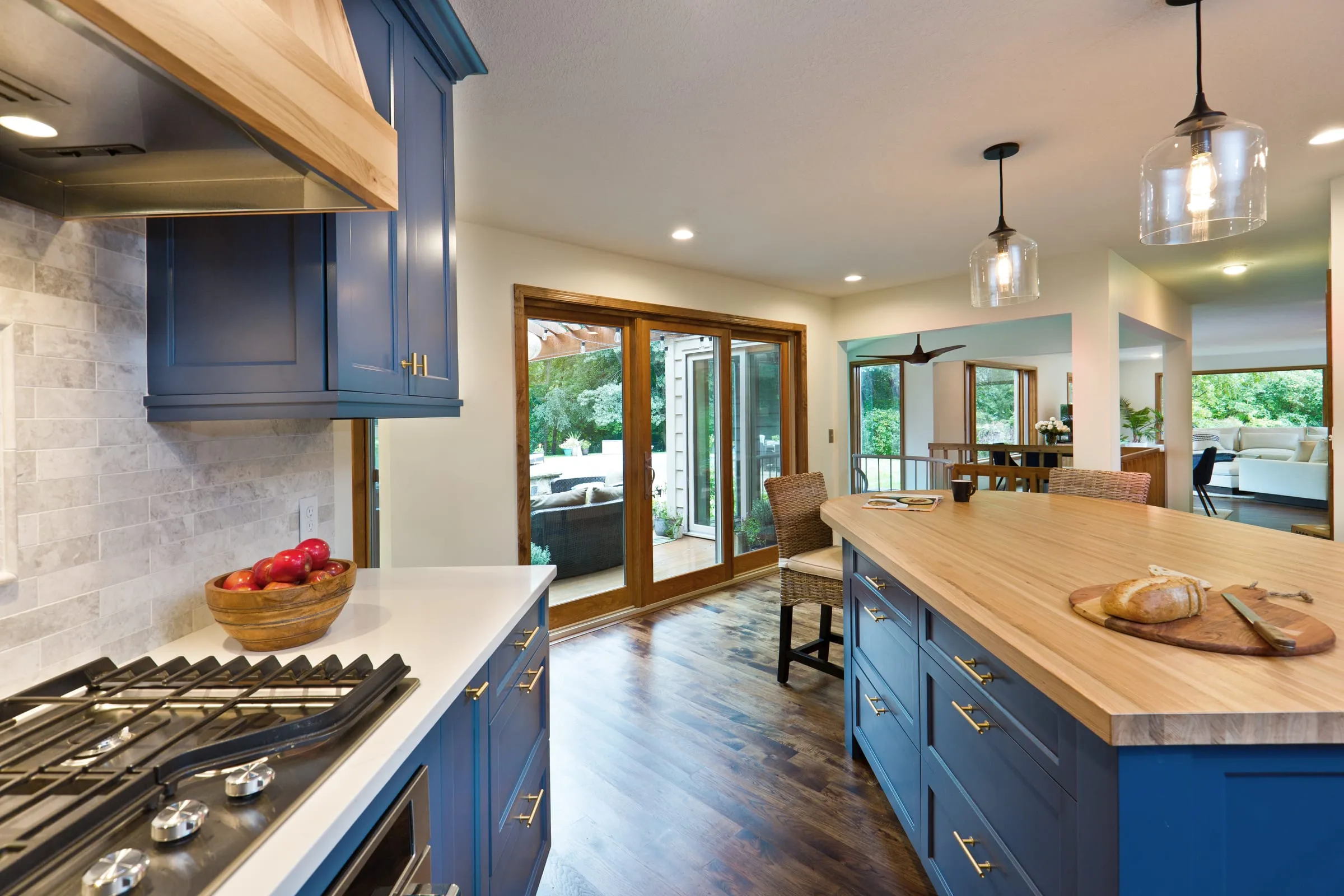 Navy blue shaker kitchen with a butcher-block island top and a wood-wrapped range hood