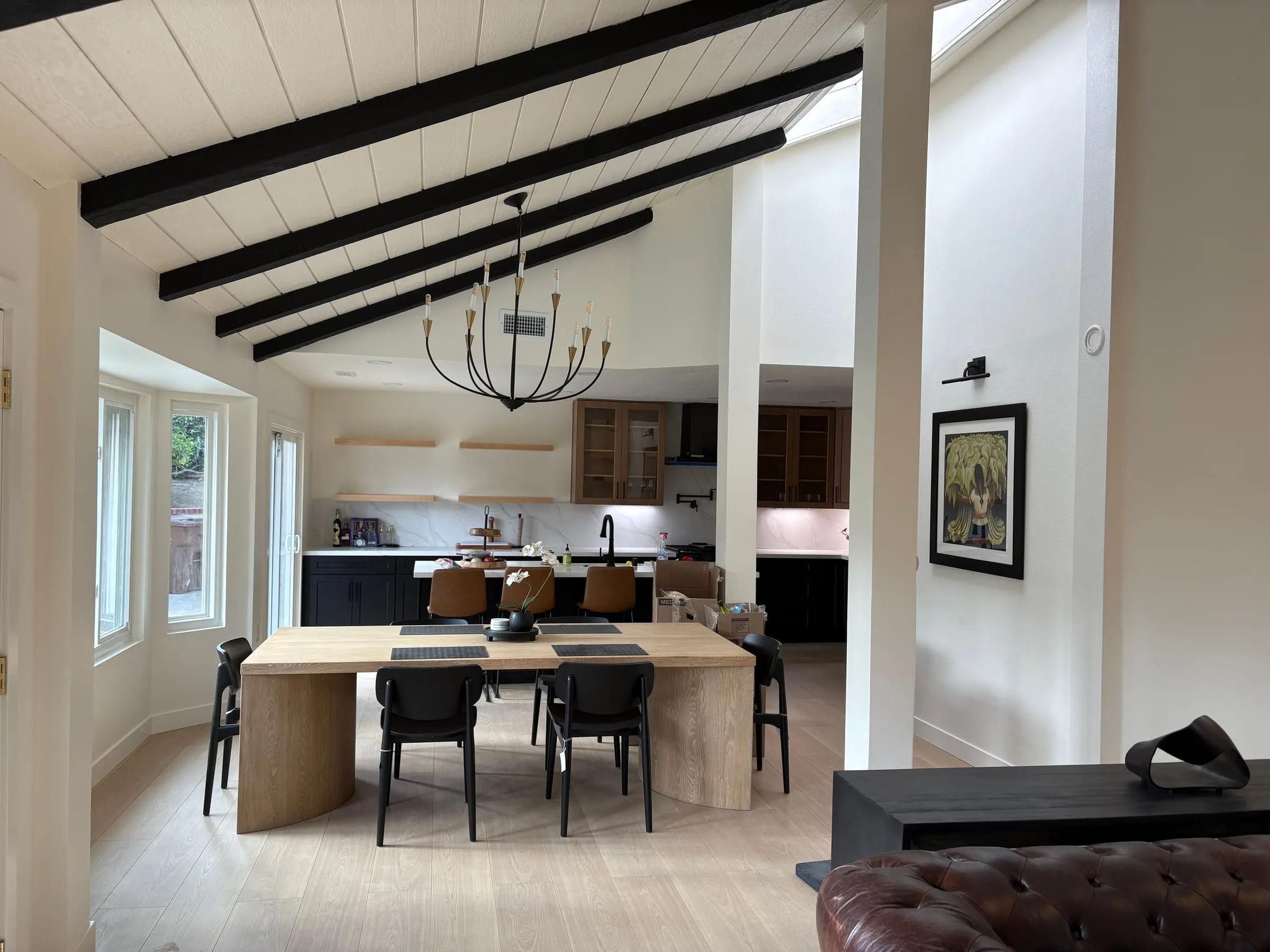Open dining area with oak-and-black glass-front cabinetry in the adjoining kitchen