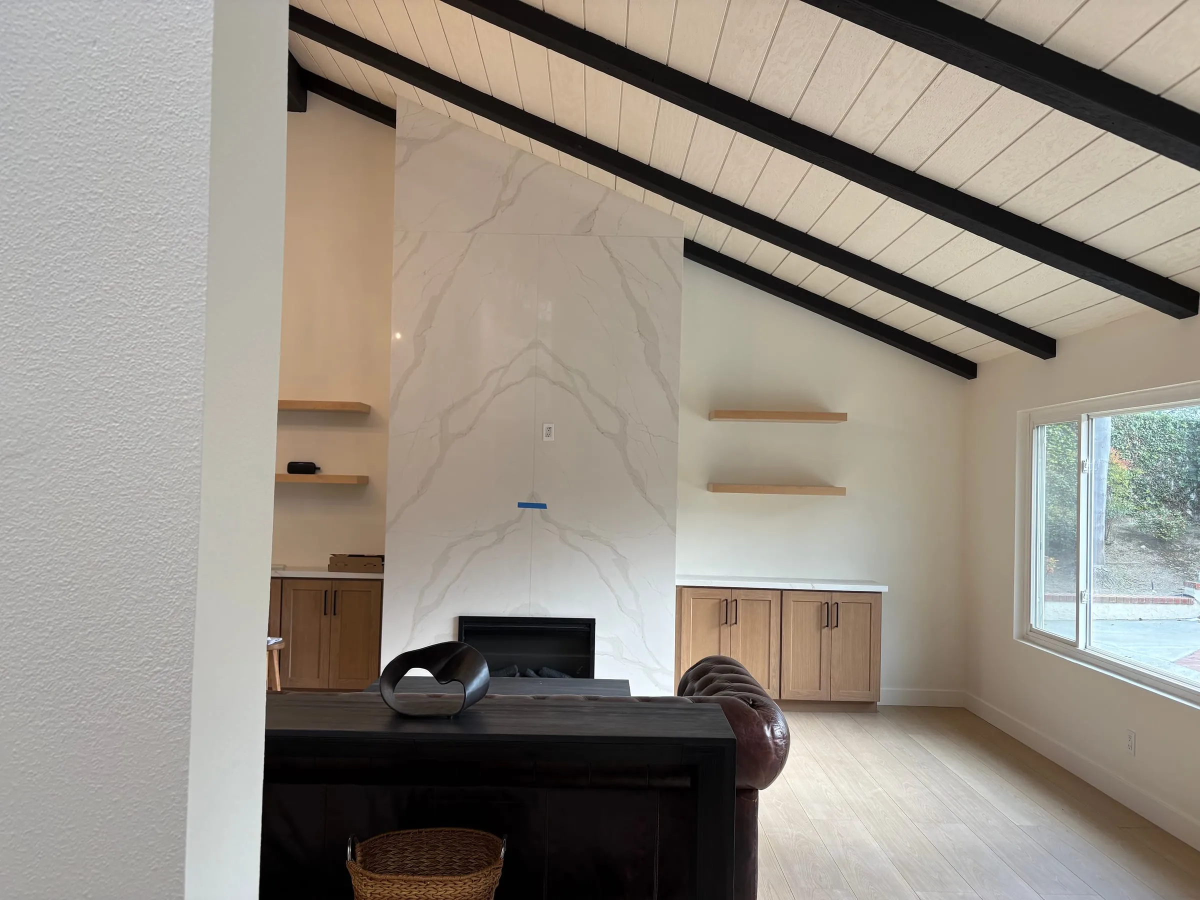 Living room with a marble fireplace and oak floating built-in credenzas