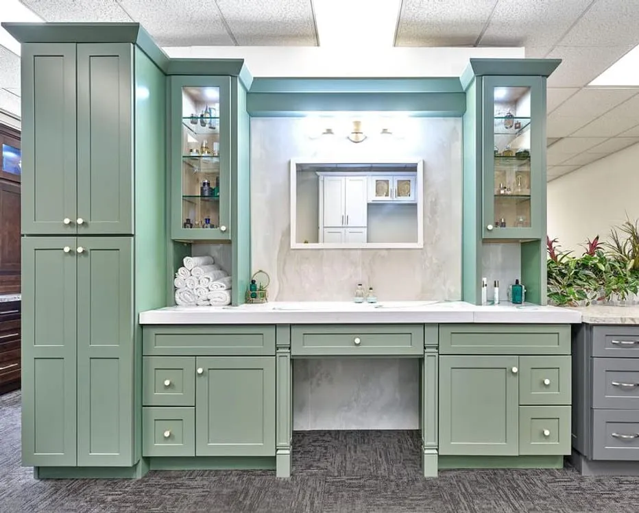 Sage-green showroom vanity with glass display towers